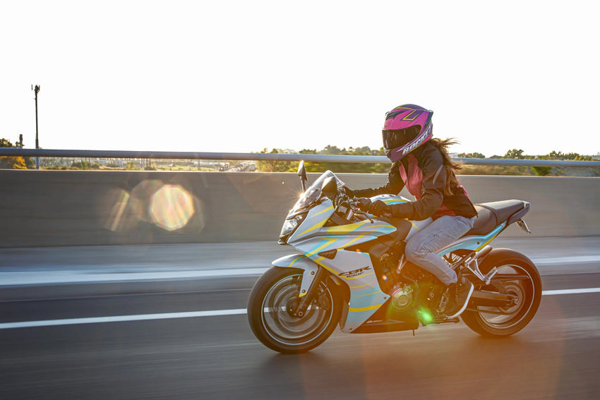 Person riding a motorcycle on a road with a blurred background