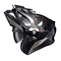 Scorpion EXO-AT960 Topographic Modular Adventure Motorcycle Helmet in Black/White shown with the modular chin bar in the fully raised position. The helmet features a matte black and grey topographic map graphic with white accent panels, a clear EverClear® face shield, integrated drop-down SpeedView® sun visor, and aerodynamic adventure peak visor. The open modular design demonstrates the helmet's convenient flip-up functionality for easier communication, fueling, and added comfort when stopped, while mainta