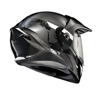 Rear three-quarter view of the Scorpion EXO-AT960 Topographic Modular Adventure Motorcycle Helmet in Black/White. The helmet features a matte black and metallic grey finish with subtle topographic map graphics and contrasting white accent panels. Visible are the aerodynamic rear spoiler, advanced ventilation ports, adventure peak visor, and clear EverClear® face shield. Designed for both on-road touring and off-road adventure riding, the EXO-AT960 combines aggressive styling, premium comfort, and rugged all