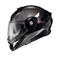 Side profile of the Scorpion EXO-AT960 Topographic Modular Adventure Motorcycle Helmet in Black/White. This adventure touring helmet features a sleek matte black and metallic grey finish with subtle topographic contour graphics and contrasting white accent panels. Equipped with a clear EverClear® face shield, integrated SpeedView® drop-down sun visor, aerodynamic shell design, and modular flip-up chin bar, the EXO-AT960 is built for long-distance touring and off-road adventure riding, offering premium comfo