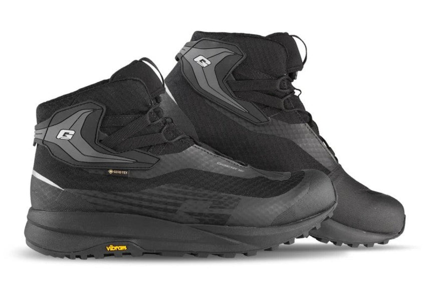 A pair of black and dark gray high-top outdoor boots with Vibram soles, shown on a clean white background.
