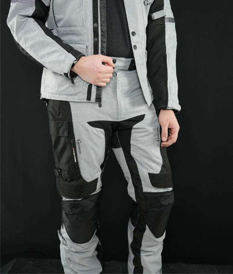 Man wearing Gryphon Men’s Pacific Coast grey and black adventure motorcycle pants with reinforced knees and matching jacket, front view.