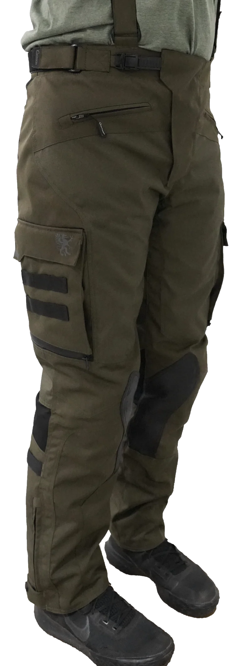 Side view of Gryphon Single Track Waterproof Motorcycle Pants in olive green. These premium adventure riding pants feature a durable waterproof textile shell, removable suspenders, adjustable waist buckle, large cargo pocket with MOLLE webbing and Gryphon logo, articulated knees with CE armour pockets, reinforced inner knee panels for improved grip, and adjustable lower leg closures. Designed for touring, adventure, and off-road motorcycle riding with all-day comfort, protection, and weather resistance.