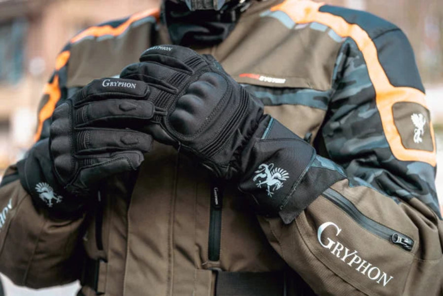 Person wearing a brown jacket and Gryphon Tofino cold Weather black motorcycle gloves with Gryphon branding.