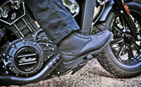 Lifestyle photo of the Joe Rocket Iron Age Waterproof Motorcycle Cruiser Boot in black being worn on an Indian motorcycle. The waterproof leather boot features a classic lace-up design, reinforced shift pad, and rugged lug sole, providing all-day comfort, protection, and traction for cruiser, touring, and everyday motorcycle riding.