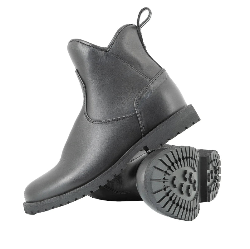 A pair of black leather Chelsea-style ankle boots with chunky lug soles, shown on a clean white background. One boot is standing upright, and the other is lying on its side to display the tread pattern of the sole.