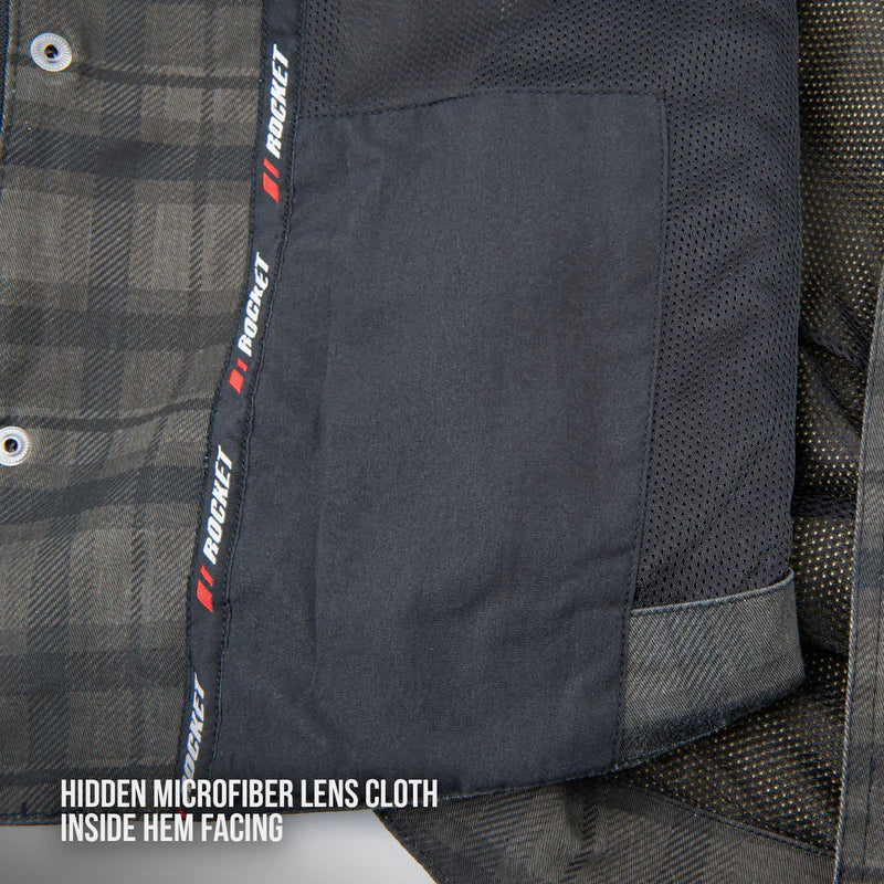 Close-up of the interior hem of the Joe Rocket Richmond™ Armored Motorcycle Shirt showing the hidden microfiber lens cloth. The soft microfiber panel is discreetly sewn into the inside hem for conveniently cleaning helmet visors, goggles, sunglasses, or glasses while on the road. The image also highlights the breathable mesh lining and premium interior construction.