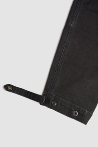 Close-up of black cargo motorcycle pantst with strap on a light gray background