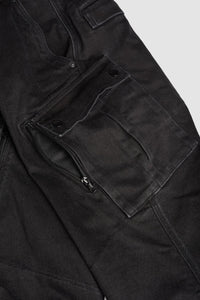 Close-up of black cargo motorcycle pants pocket with zippers and buttons on a light gray background