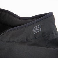 Close-up of a dark gray or black textured fabric garment, showing a collar with a stitched gray double-S logo and a dark interior lining.