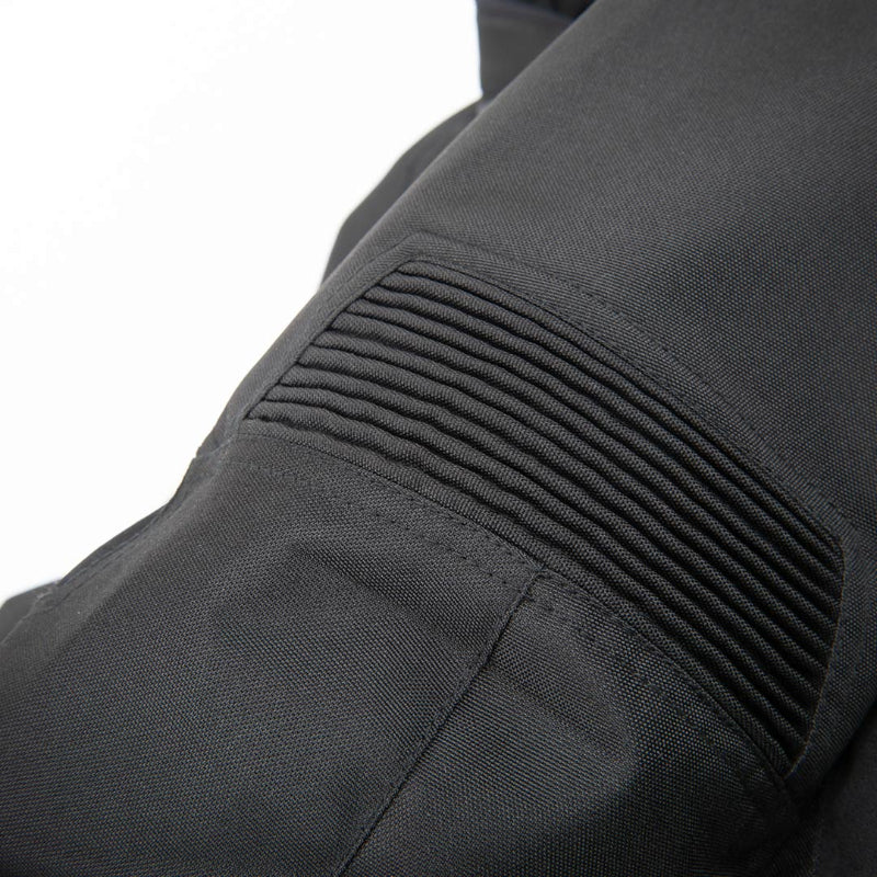 Close-up detail of a black technical jacket showing a ribbed pleated pocket on a white background.
