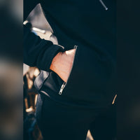 Close-up of the MotoGirl Sherrie black women's motorcycle jacket showing the silver zippered exterior pocket and hand inside.
