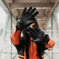 Lifestyle image of a rider wearing the MotoGirl Amina Women's Motorcycle Gloves, highlighting the premium leather palms, slim fit, and flexible construction. Designed for comfort, protection, and everyday riding, these motorcycle gloves feature touchscreen-compatible fingertips, secure wrist closures, and a sleek, understated style that pairs perfectly with touring, commuting, and urban riding gear.