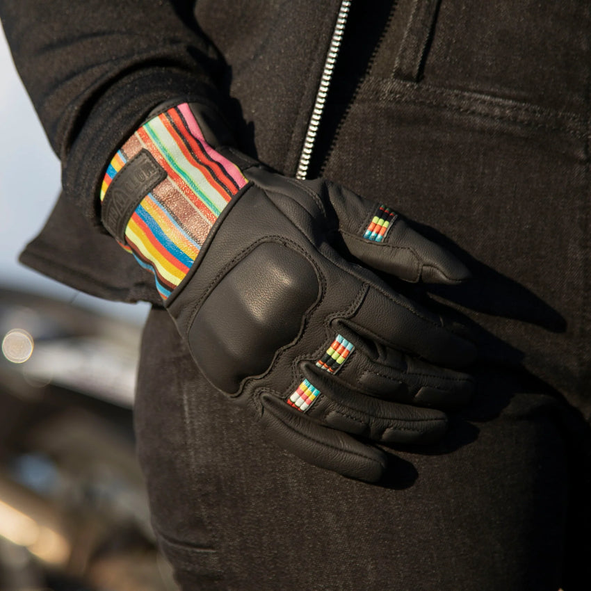 A black with coloured stripes Bessie motorcycle glove featuring knuckle protection and the Motorgirl brand logo on the wrist.