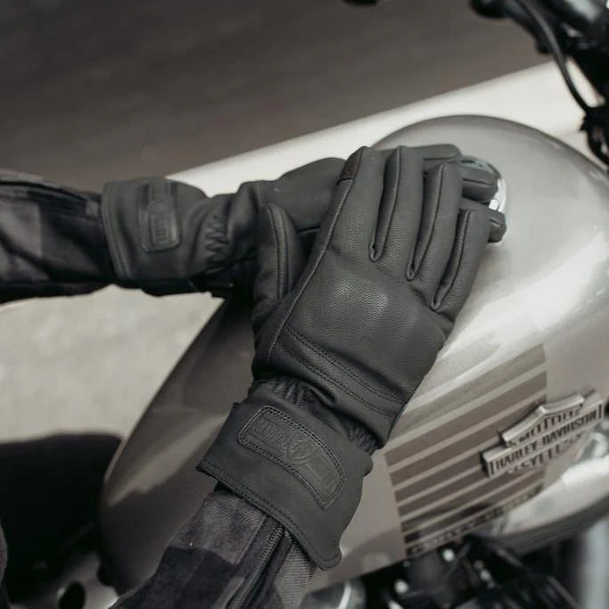 A person wearing black MotoGirl NANDI Winter Gloves on a motorcycle, showcasing the gloves' design and fit.
