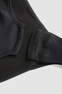 The closeup of the crotch closure system for the pando Moto Shell ww on a grey background