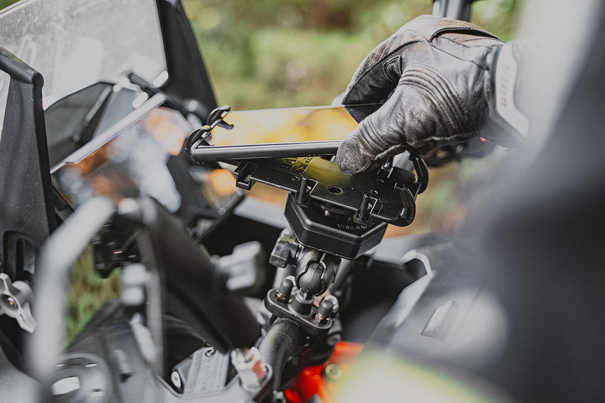 Person using a smartphone app on a motorcycle with a blurred background