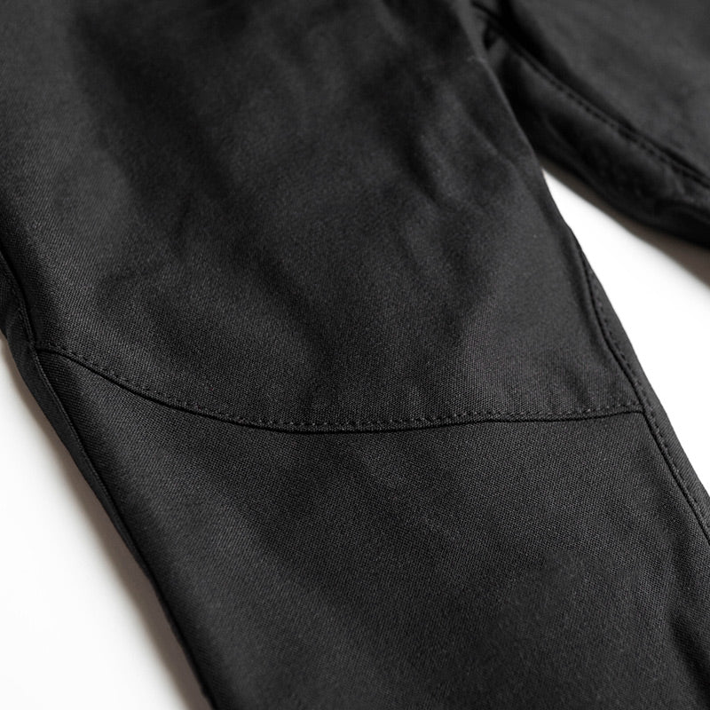 Close-up of a black motorcycle pants stitching on a white background