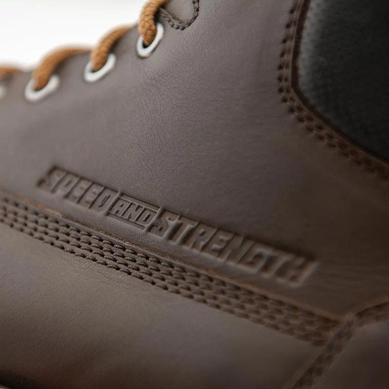 Close-up of the Speed and Strength CALL TO ARMS Motorcycle Boot showcasing the premium brown leather upper with embossed Speed and Strength branding and durable stitched construction. Designed to deliver long-lasting durability, classic motorcycle styling, and dependable comfort for everyday riding.