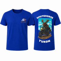 Front and back of a royal-blue YMGA Whitehorse Yukon T-shirt featuring a moose in sunglasses riding an adventure motorcycle through mountain terrain.