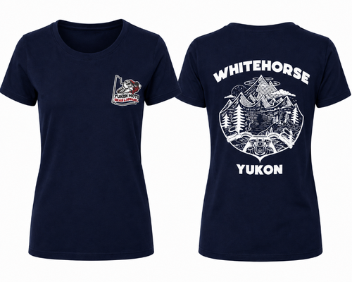 Women's navy blue T-shirt featuring a small Yukon Moto Gear & Apparel logo on the left chest. The back displays a bold white Whitehorse, Yukon graphic with mountains, trees, a lake, and off-road handlebars, celebrating adventure in the Yukon.